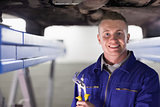 Smiling mechanic holding an adjustable pliers