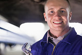 Mechanic holding an adjustable pliers while looking at camera