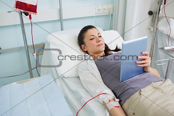 Female transfused holding a tablet computer