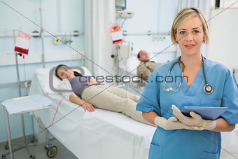 Nurse next to patients holding a clipboard