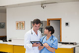 Doctor holding a tablet computer next to a nurse
