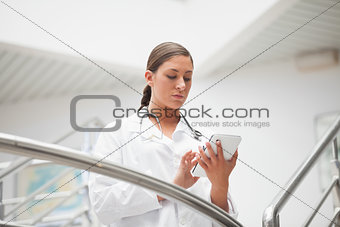 Serious doctor holding a tablet computer