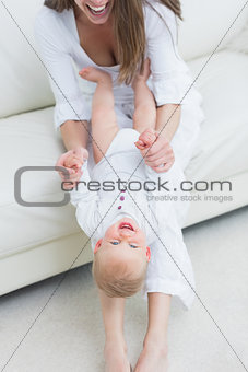 Mother sitting on a sofa playing with a baby