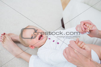 Mother sitting on a sofa while playing with a baby