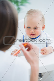 Baby looking at a plastic spoon