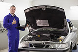 Mechanic holding a computer with thumb up