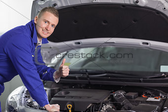 Mechanic looking at camera with his thumb up