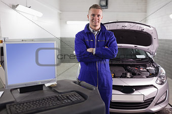 Mechanic next to a car and a computer
