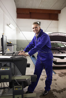 Mechanic using a computer while smiling