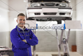 Smiling mechanic standing with arms crossed