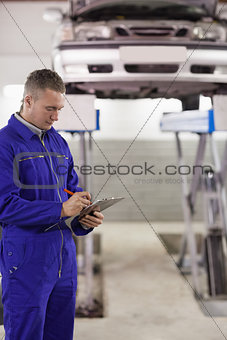 Concentrated mechanic holding a clipboard