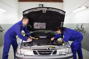 Mechanics examining a car engine