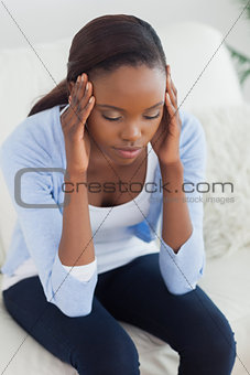 Close up of a black woman holding her head