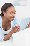 Black woman holding a tablet computer and looking at it