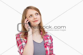 Woman looking up while holding a mobile phone