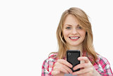 Smiling woman using a mobile phone while looking at camera