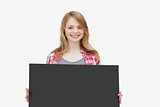 Woman looking at camera while holding a black board