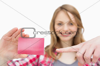 Woman holding a loyalty card while showing it with a finger