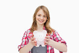 Woman holding a piggy bank while smiling