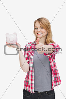 Woman smiling while holding a piggy bank