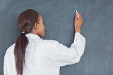 Teacher smiling while writing on a blackboard  
