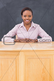 Teacher smiling while sitting at her desk