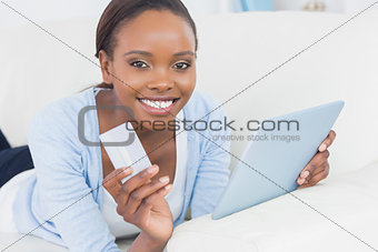 Black woman holding a tablet computer and a credit card