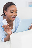 Black woman smiling while holding a credit card