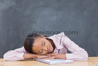 Black woman leaning her head on desk with closed eyes
