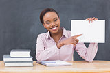 Black teacher holding a blank paper while smiling