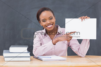 Black teacher holding a blank paper while smiling