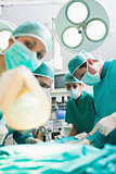 Nurse holding an oxygen mask next to surgeons