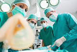 Focus on a surgical team holding an anesthesia mask