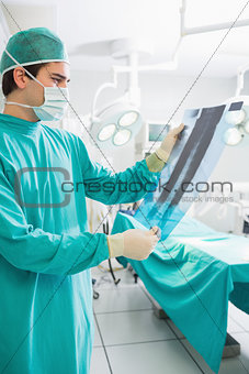 Surgeon holding a X-ray while looking at it