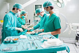 Side view of a surgical team operating a patient