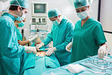 Nurse holding surgical tool next to operating table