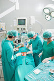 Group of surgeon operating an unconscious patient in an operatin