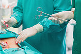 Close up of a surgical scissors next to a patient