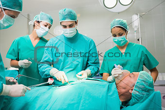 Surgical team performing on a patient belly