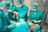 Nurse giving a surgical tool to a surgeon