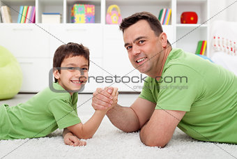 Father arm wrestling with his boy