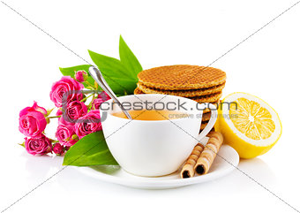 tea in cup with waffles and bouquet roses