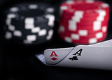 two aces high on black table with chips on black background