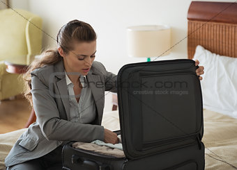 Business woman unpack luggage in hotel room