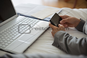 Closeup on business woman working on bed in hotel room