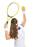 Tennis player ready to serve ball. rear view