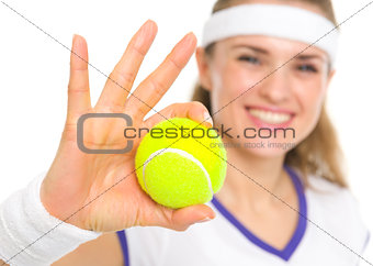 Closeup on ball in hand of smiling tennis player