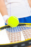 Closeup on tennis player balancing ball on racket