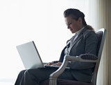 Silhouette of business woman working on laptop