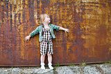 Little Girl in Green Jacket and White Socks by a Wall